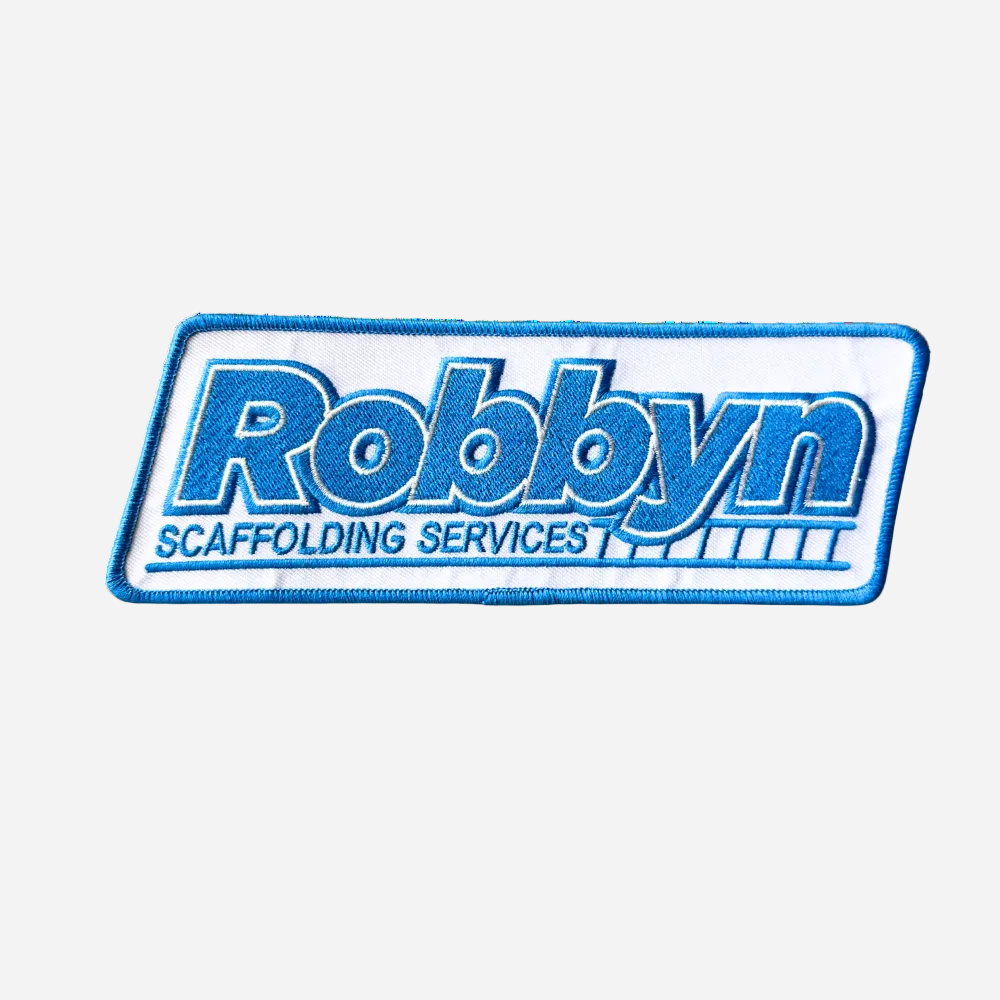 A white patch with the text 'Robbyn Scaffolding Services' in blue, featuring a blue stitch on white twill background.