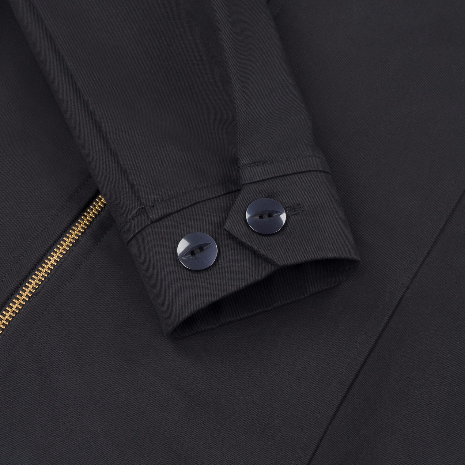 Detail shot of the Robbyn black workwear jacket cuff showing the adjustable button closure, reinforced stitching, and durable cotton fabric.