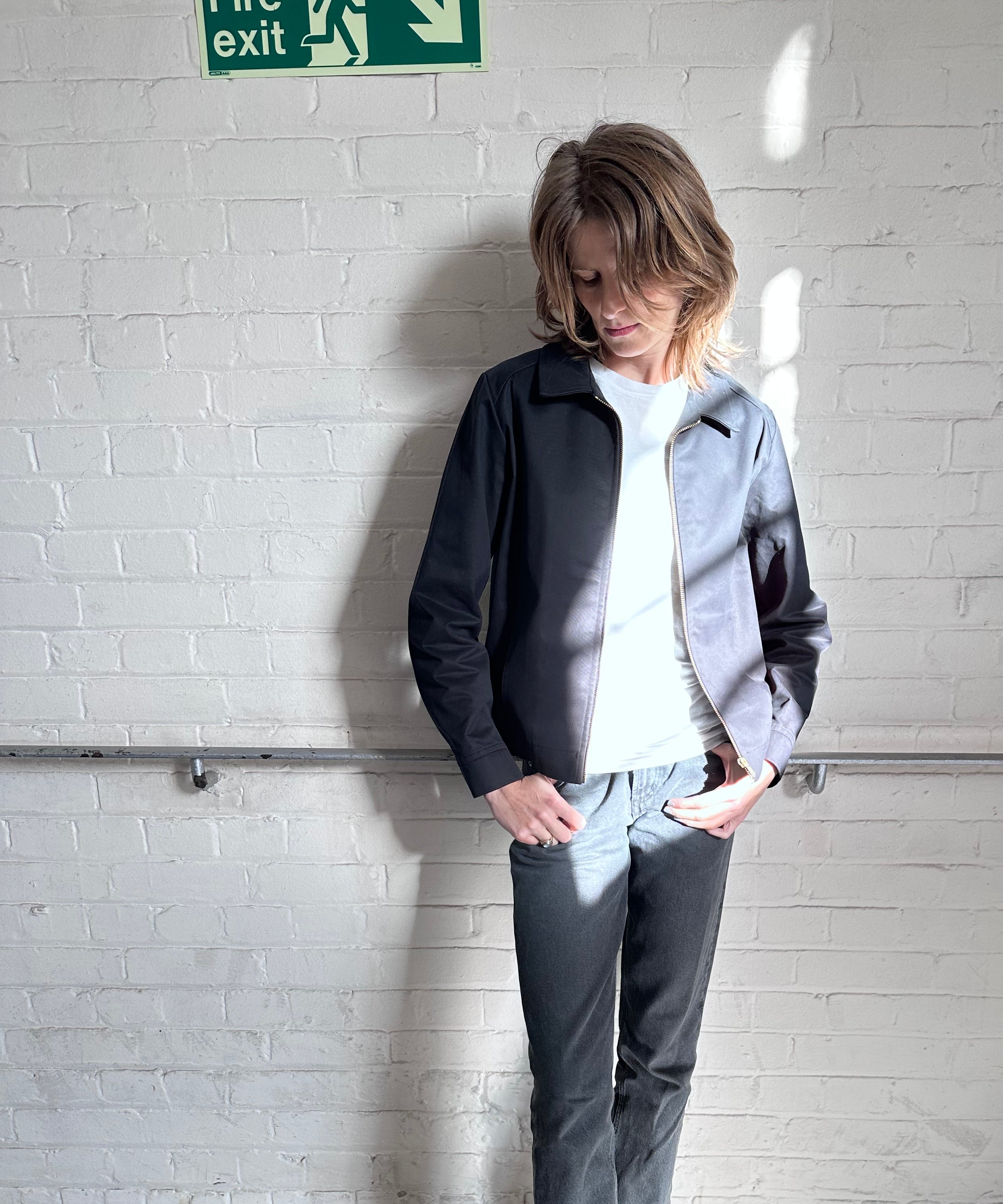 Female model wearing the Robbyn black Mechano workwear jacket, styled with a white T-shirt, grey jeans in London.
