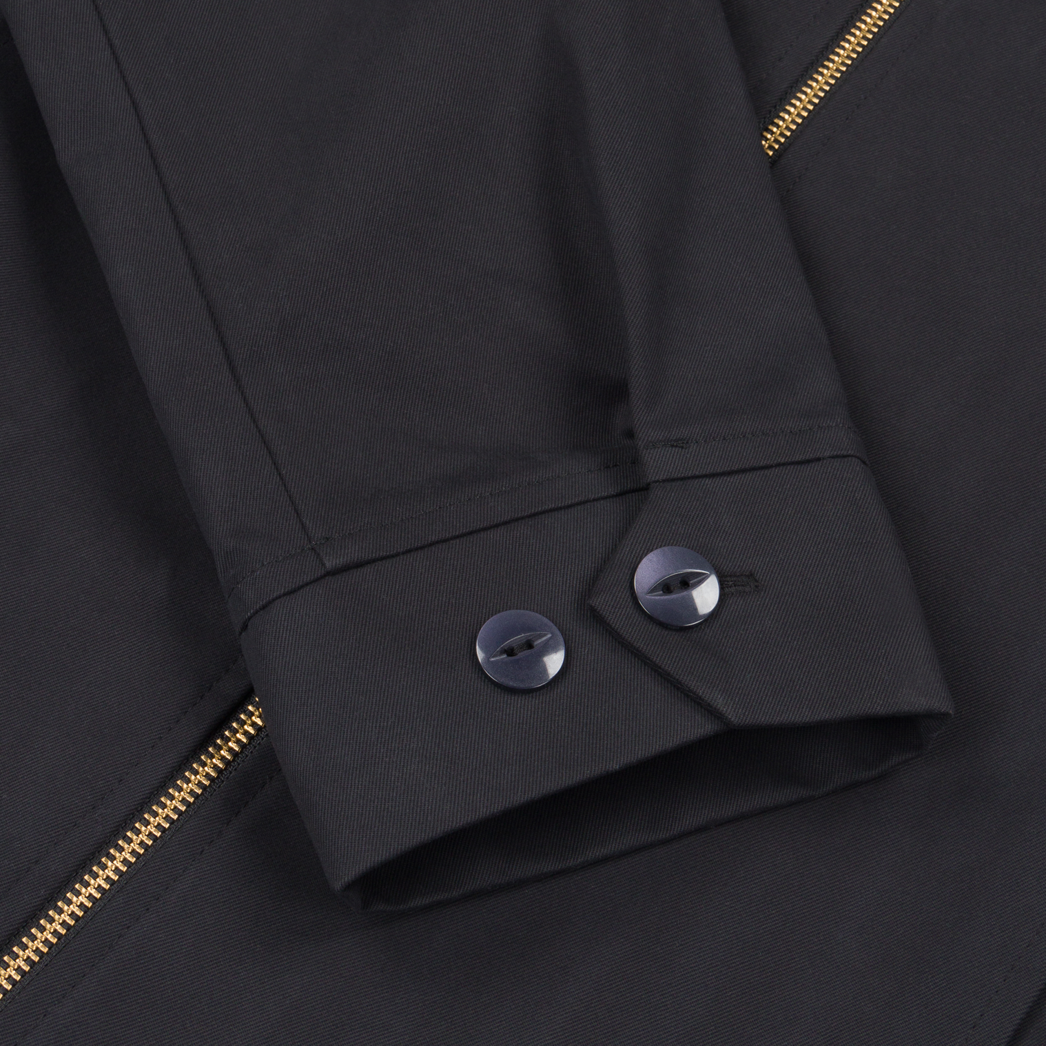 Detail shot of the Robbyn black workwear jacket cuff showing the adjustable buttons closure, reinforced stitching, and durable cotton fabric.