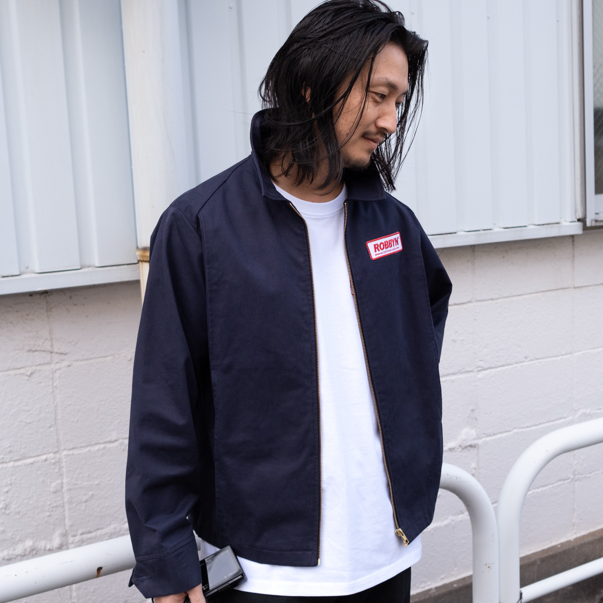 Model wearing the Robbyn navy workwear jacket, showcasing the unisex boxy silhouette and utility-inspired details.