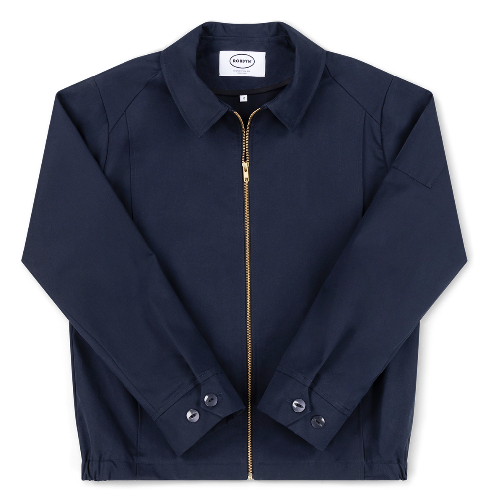 Robbyn unisex navy workwear jacket shown from the front, featuring a boxy fit, reinforced seams, adjustable buttoned cuffs, and minimal detailing.