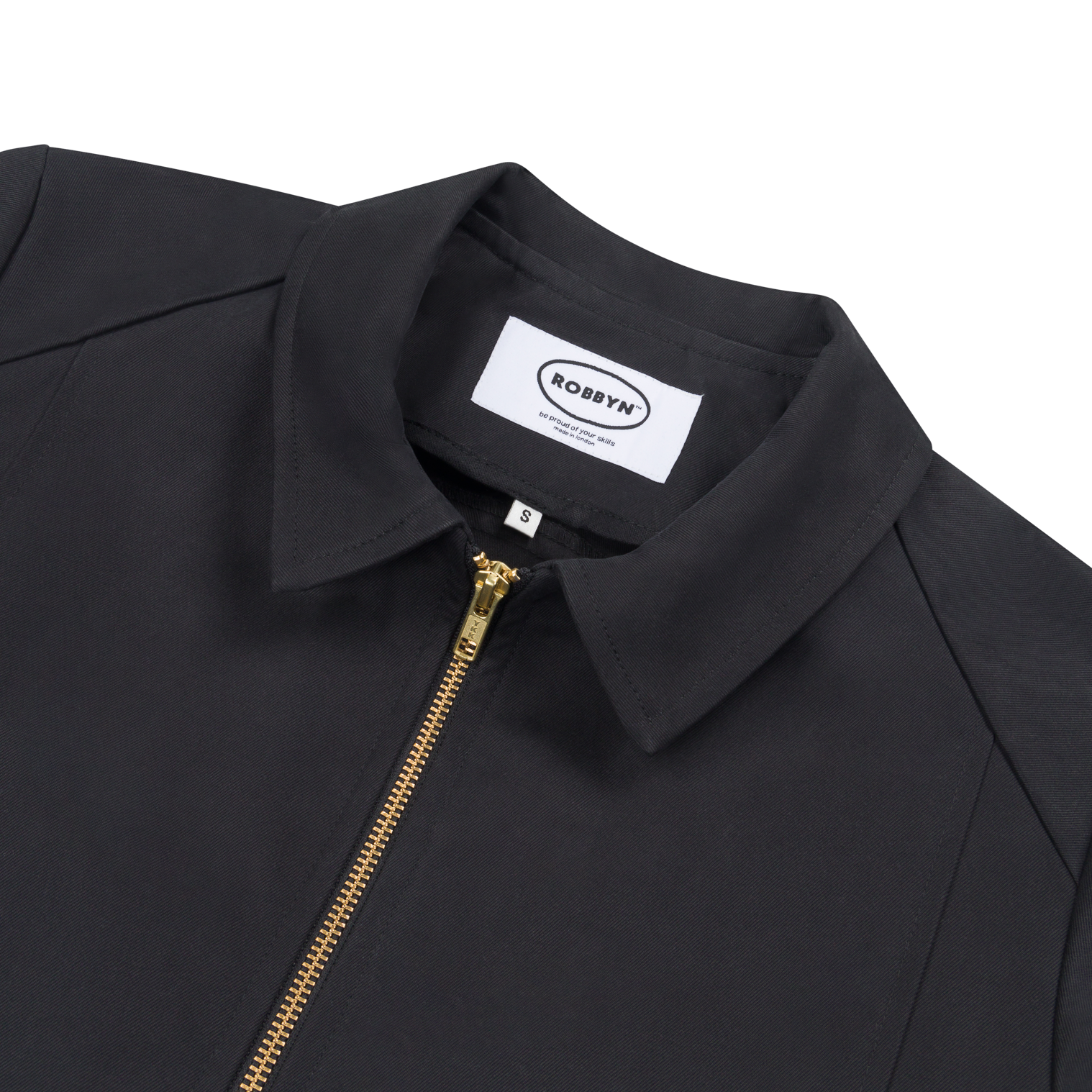 Close-up detail of the jacket’s metal zip and collar on the black workwear-style jacket.