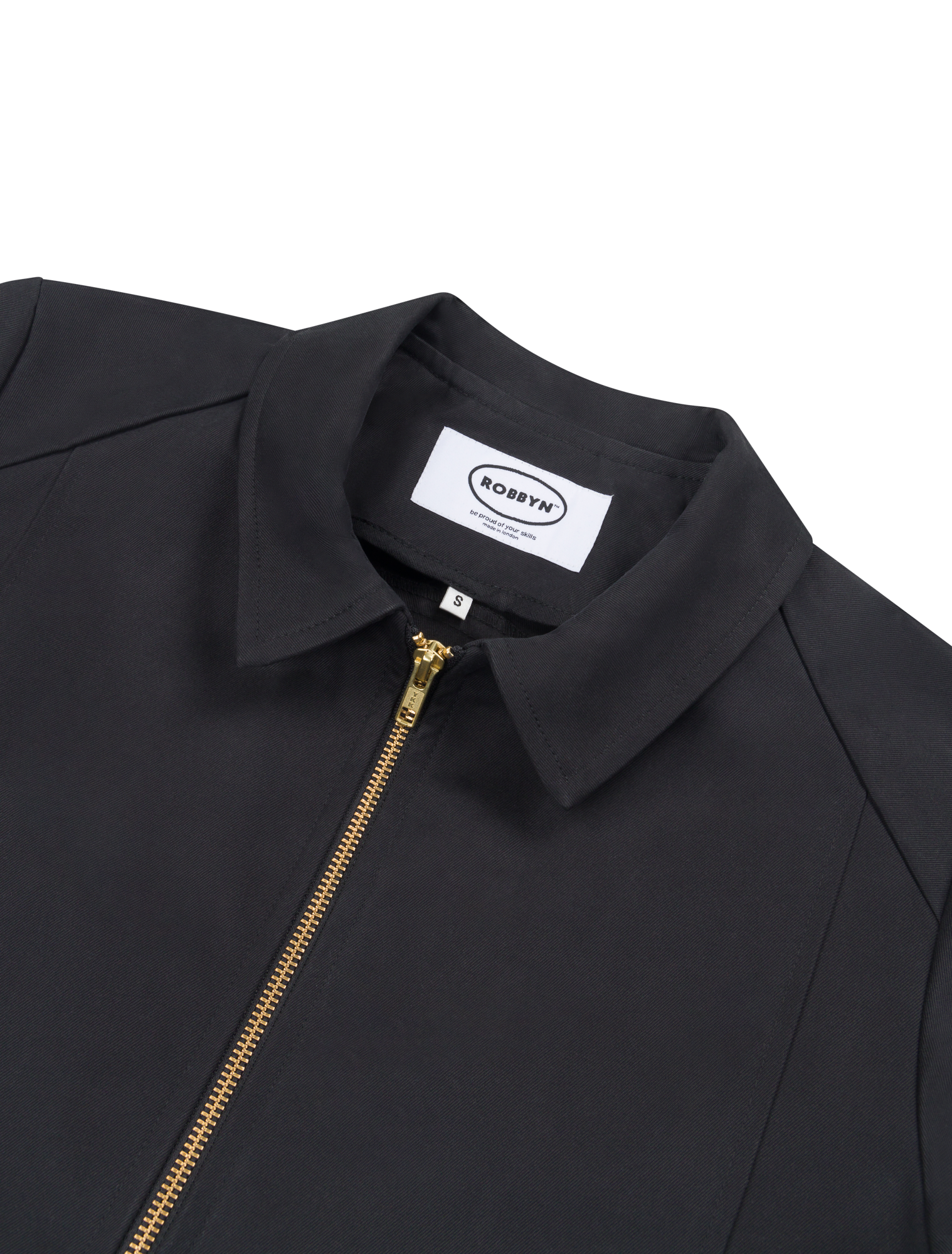 Close-up detail of the jacket’s metal zip and collar on the black workwear-style jacket.