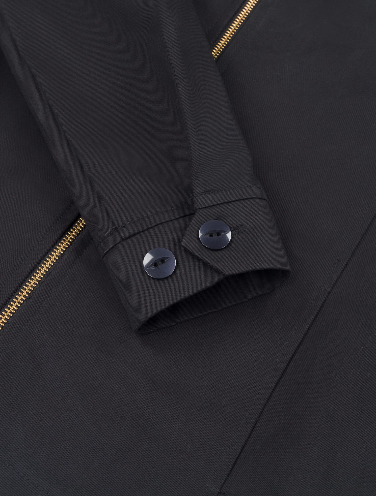 Detail shot of the Robbyn black workwear jacket cuff showing the adjustable button closure, reinforced stitching, and durable cotton fabric.