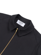 Close up of the Robbyn signature black Mechano jacket, a unisex workwear-inspired silhouette with clean lines and chunky zip.