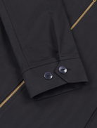 Detail shot of the Robbyn black workwear jacket cuff showing the adjustable buttons closure, reinforced stitching, and durable cotton fabric.